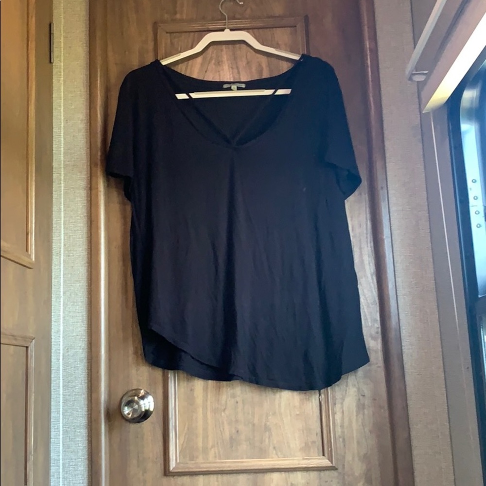 Black a-symmetrical top with cross chest detail.